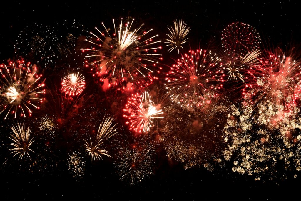 Red and Orange firework bursts in a black sky